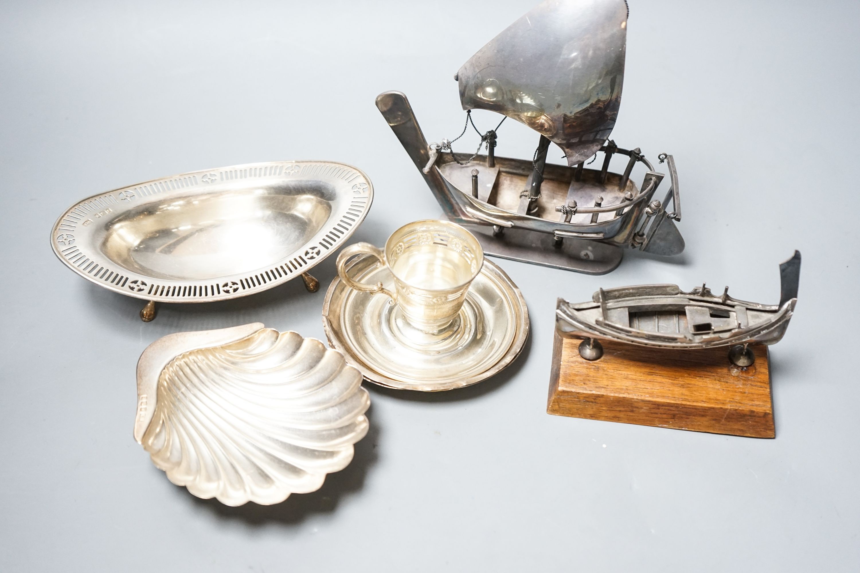 A silver butter shell and a pierced silver dish, two coin dishes and two boat models etc.